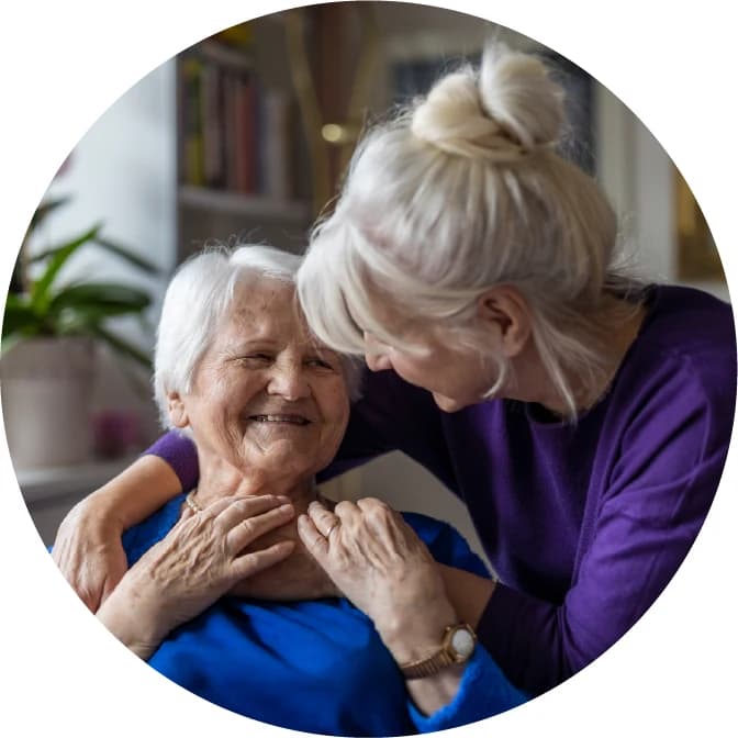 A woman tenderly supporting an elderly woman, illustrating the caregiving journey