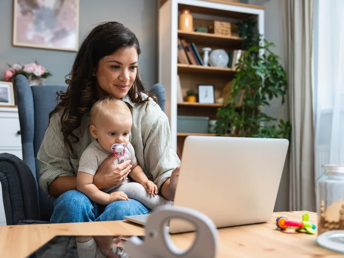 Mother working on a laptop while caring for her baby