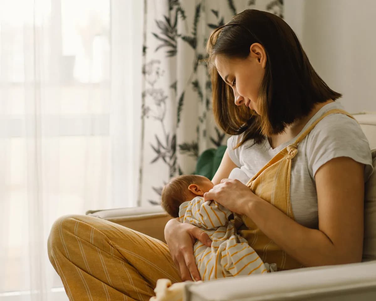 Mother breastfeeding her newborn in a tender, intimate moment