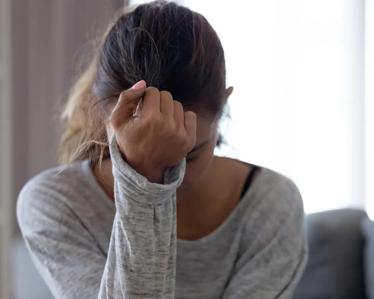 Woman sitting quietly, holding the weight of grief and loss