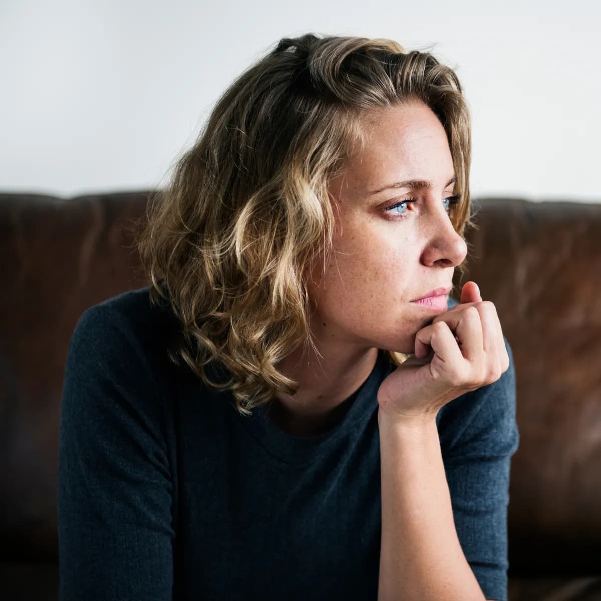 Woman gazing through a window, reflecting on feelings of anxiety