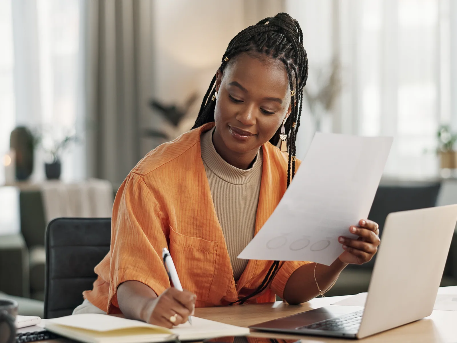 Woman working thoughtfully at a laptop in a home office