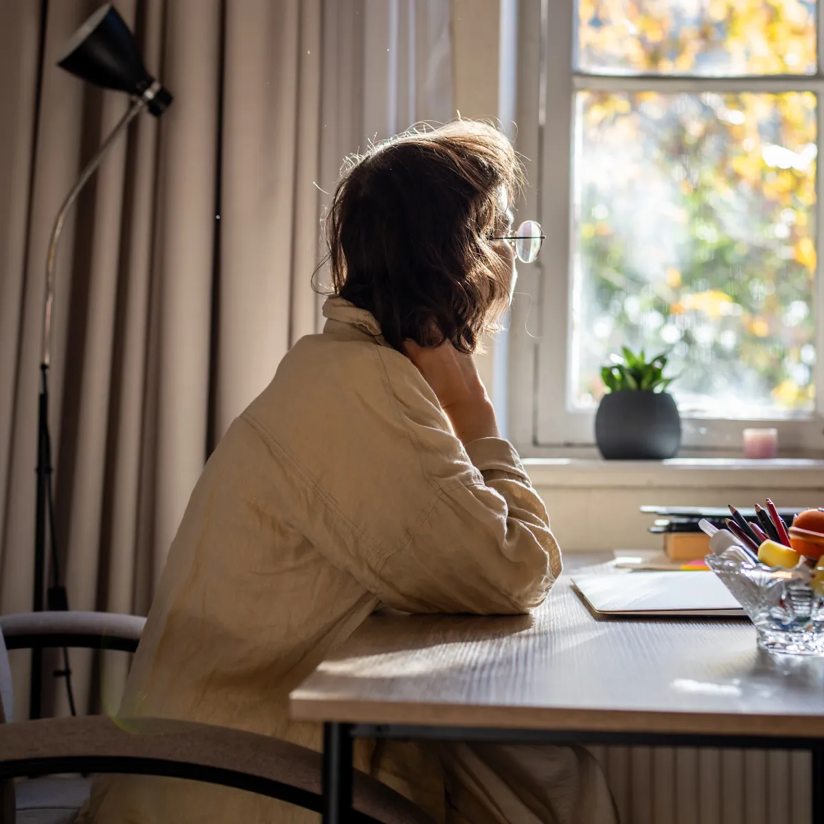 Woman at her desk, distracted and struggling to focus