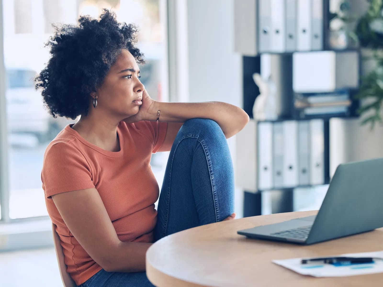 Woman at her laptop, frustrated and exhausted by the pressure of perfectionism