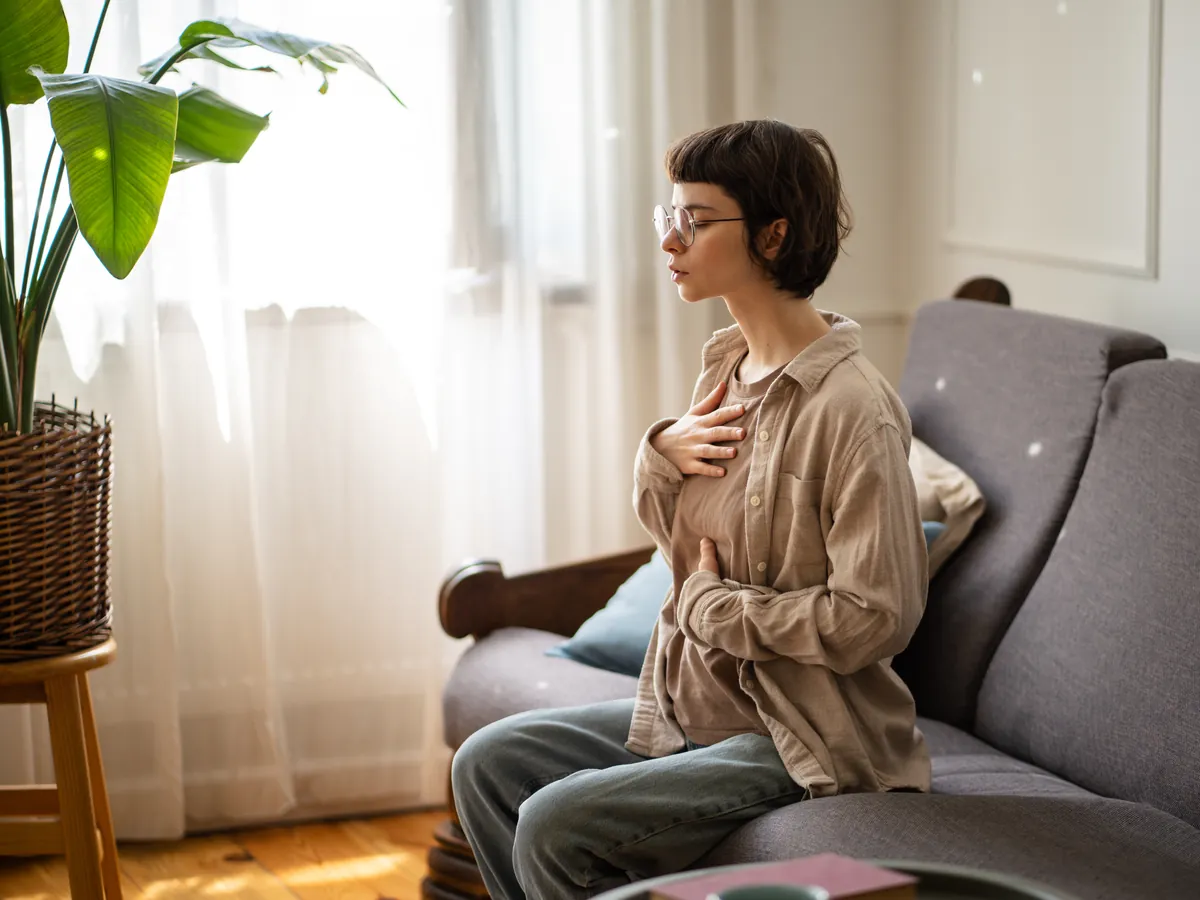 Woman practicing diaphragmatic breathing with hands on her torso